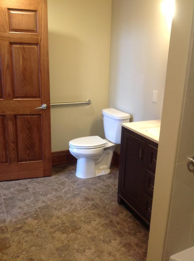 bathroom with toilet, tile floors, and vanity