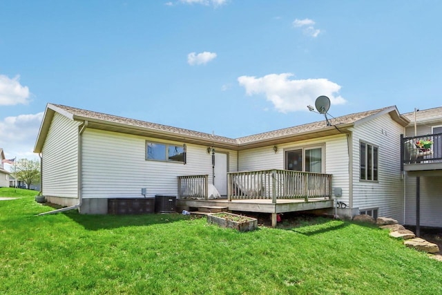 rear view of house featuring central AC, a wooden deck, and a yard