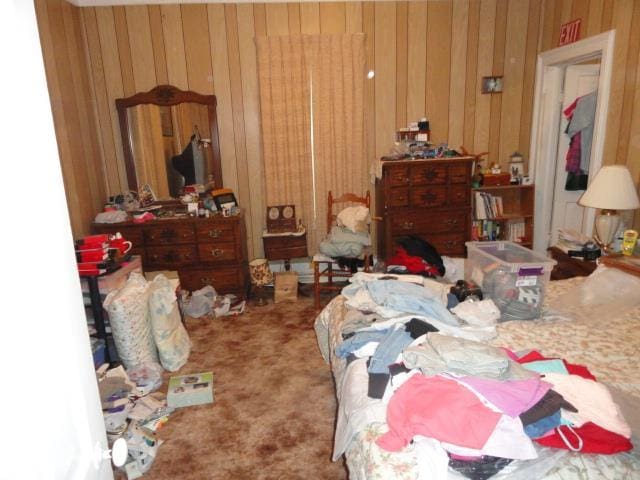 bedroom with wooden walls and carpet flooring