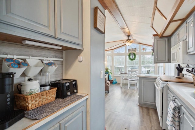 kitchen with light hardwood / wood-style flooring, white appliances, ceiling fan, lofted ceiling, and gray cabinetry