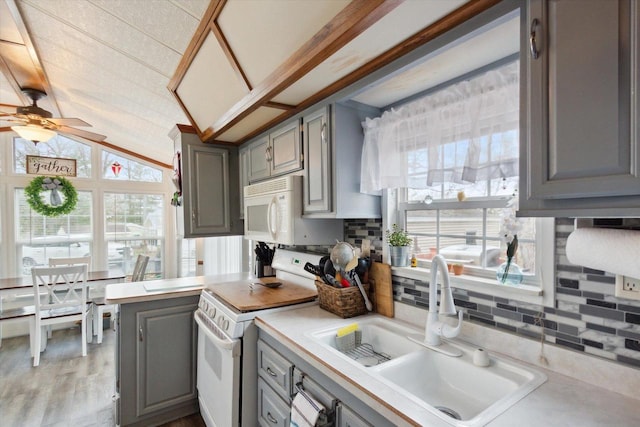 kitchen with ceiling fan, sink, light hardwood / wood-style floors, white appliances, and vaulted ceiling