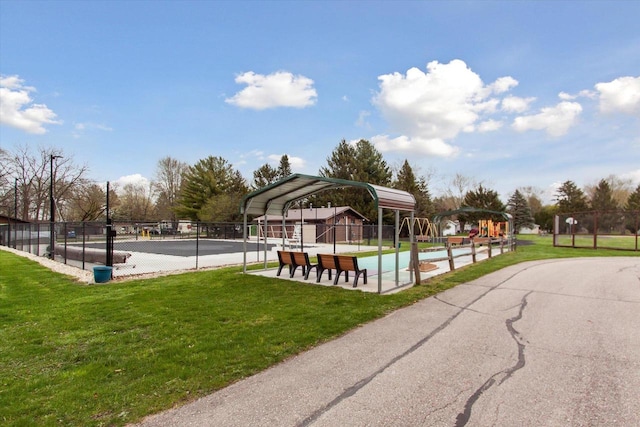 view of property's community with a swimming pool and a lawn