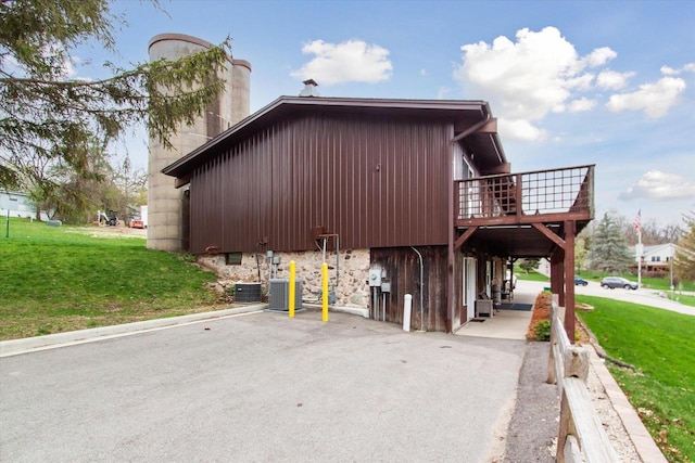 view of side of home featuring a lawn and central air condition unit