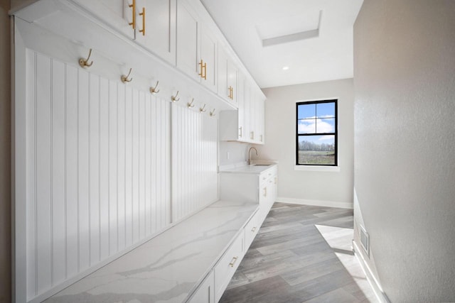 mudroom with sink and light hardwood / wood-style floors