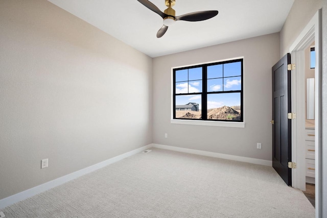 carpeted spare room with ceiling fan