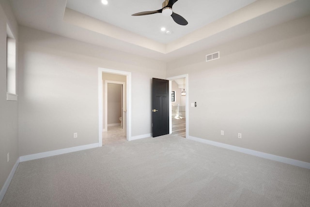 unfurnished room with carpet flooring, ceiling fan, and a tray ceiling