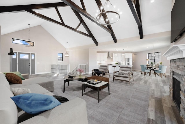 living room featuring high vaulted ceiling, a fireplace, beam ceiling, and a chandelier