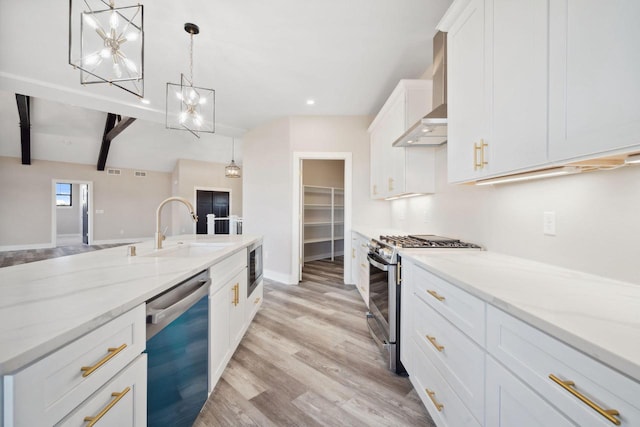 kitchen with decorative light fixtures, wall chimney range hood, stainless steel appliances, beam ceiling, and light hardwood / wood-style floors