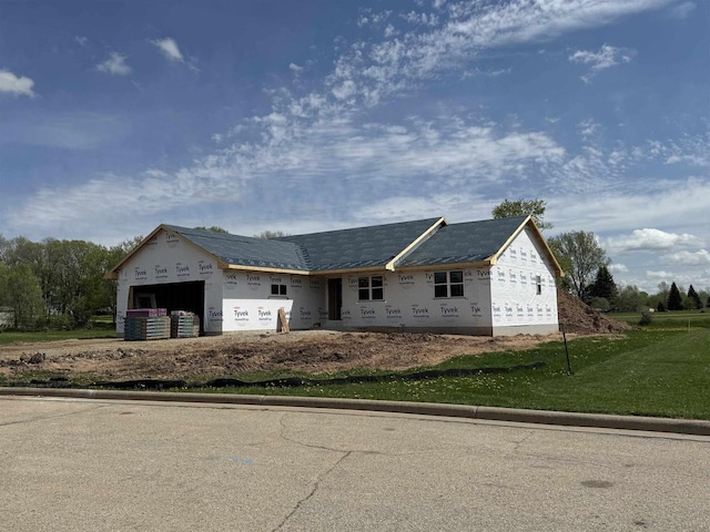 unfinished property featuring a garage and a front yard