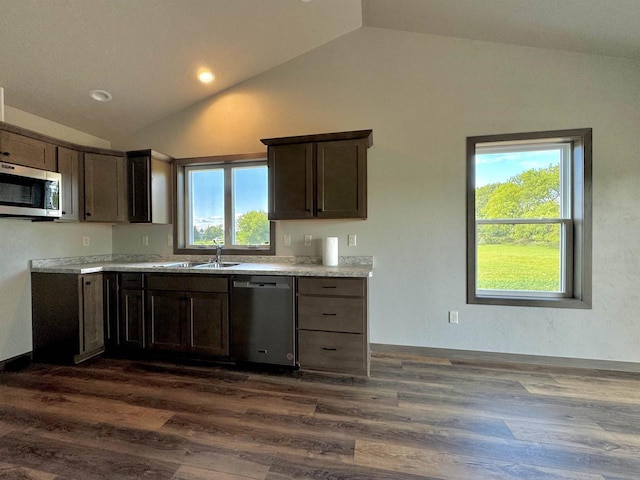 kitchen with appliances with stainless steel finishes, dark wood-type flooring, lofted ceiling, and dark brown cabinetry