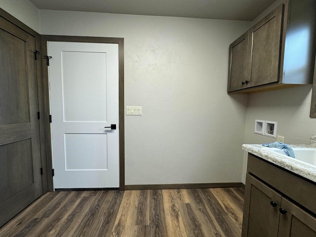 laundry area featuring cabinets, sink, dark hardwood / wood-style flooring, and hookup for a washing machine