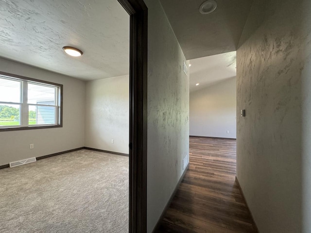 hall featuring a textured ceiling