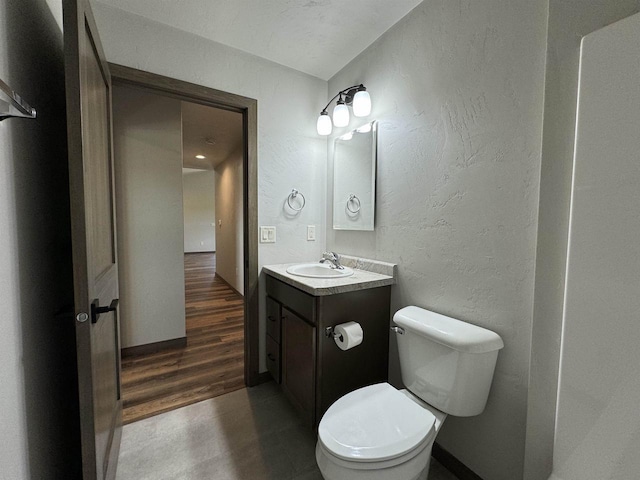 bathroom with hardwood / wood-style flooring, vanity, and toilet