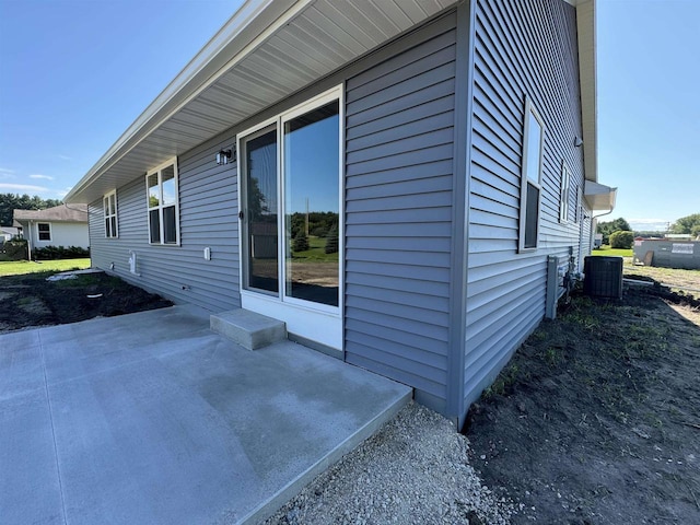 view of side of property with a patio and central AC