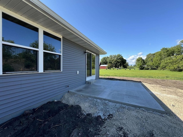 view of side of home featuring a lawn and a patio