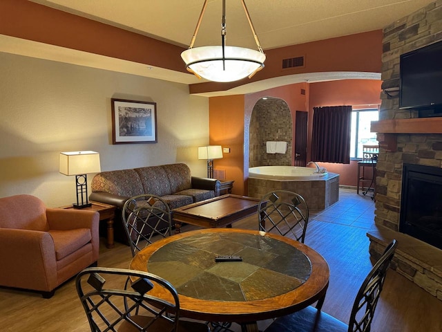 living room with wood-type flooring, a fireplace, and a textured ceiling