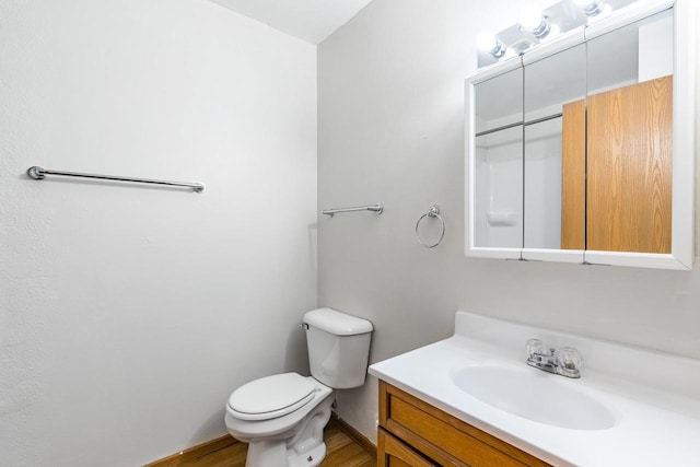 bathroom featuring vanity, hardwood / wood-style flooring, and toilet