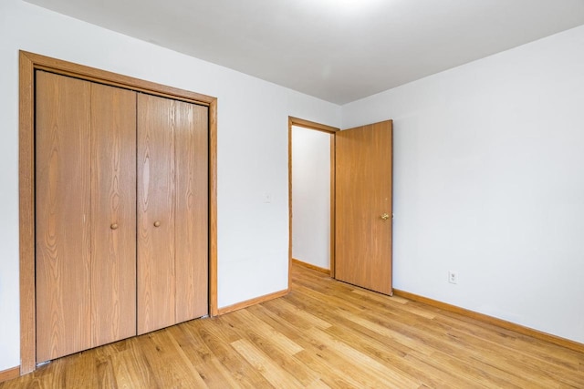 unfurnished bedroom featuring a closet and light wood-type flooring