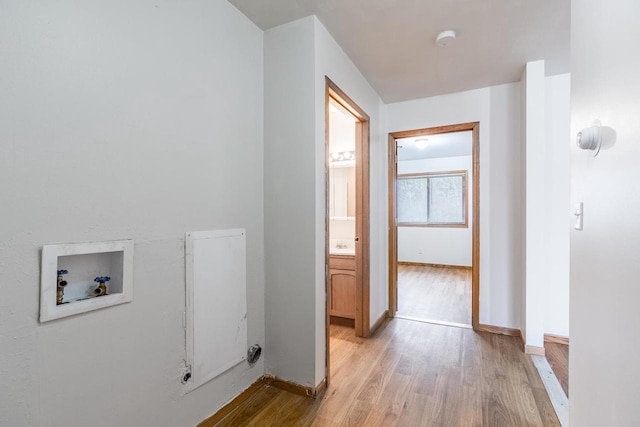 clothes washing area featuring light hardwood / wood-style flooring and washer hookup