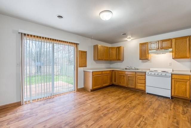 kitchen featuring white gas range, sink, and light wood-type flooring