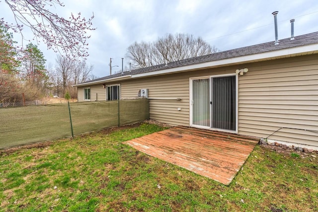 rear view of house featuring a wooden deck and a lawn