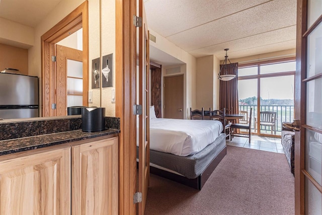 carpeted bedroom featuring stainless steel fridge and access to exterior