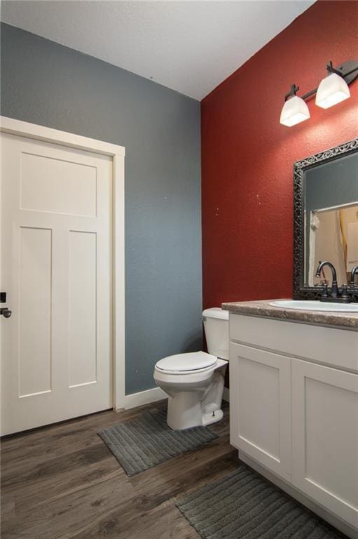 bathroom featuring vanity, toilet, and hardwood / wood-style floors