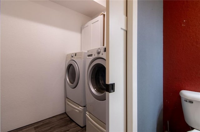 laundry area with washing machine and dryer and dark wood-type flooring