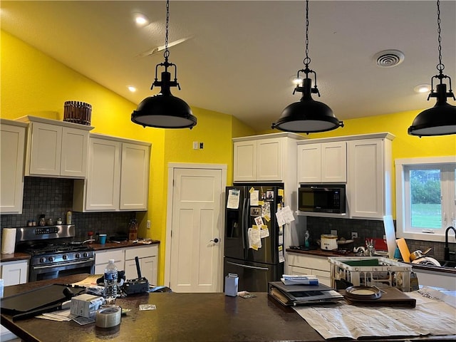 kitchen with black appliances, white cabinets, backsplash, and vaulted ceiling