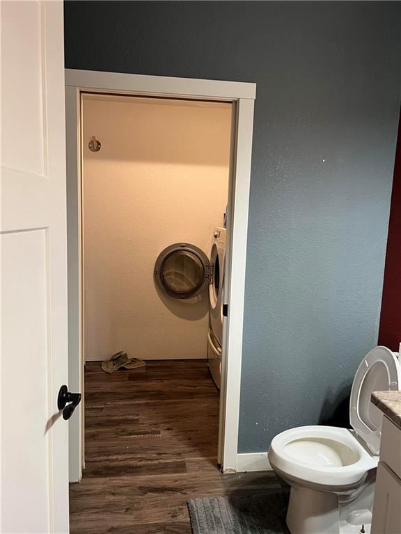 bathroom with toilet, wood-type flooring, washer / dryer, and vanity