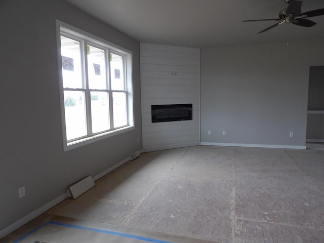 unfurnished living room with ceiling fan and a fireplace