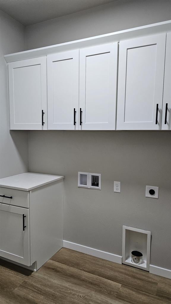 laundry room with cabinets, hookup for a washing machine, dark hardwood / wood-style flooring, and hookup for an electric dryer