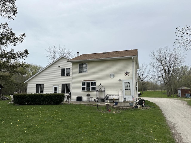 back of property with a yard and an outdoor structure