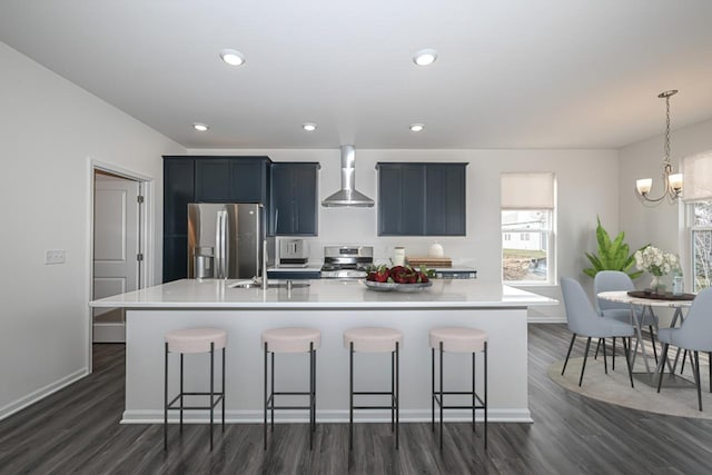 kitchen featuring an island with sink, stainless steel fridge with ice dispenser, wall chimney range hood, and a breakfast bar