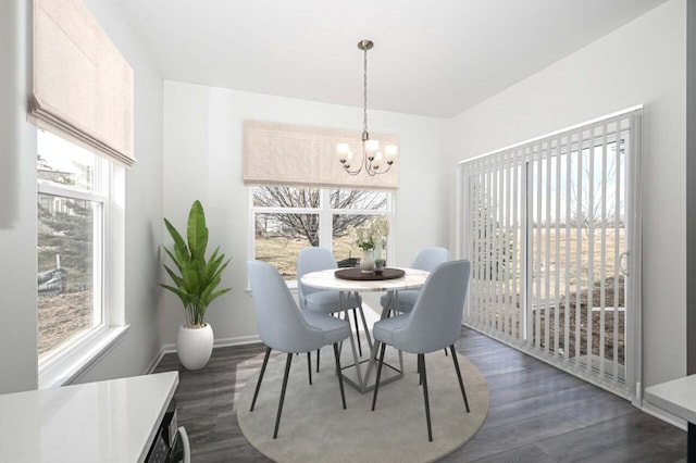 dining space with dark hardwood / wood-style flooring and an inviting chandelier