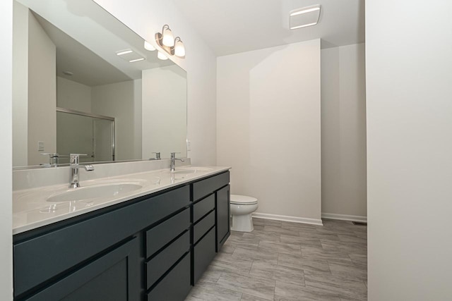 bathroom featuring vanity with extensive cabinet space, tile floors, toilet, and dual sinks