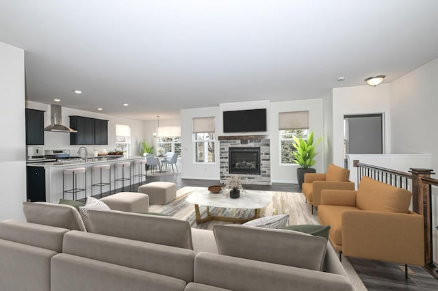 living room with sink, a stone fireplace, and dark hardwood / wood-style floors