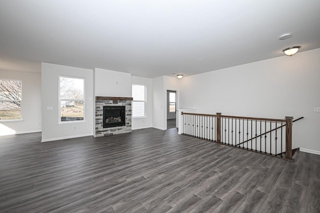 unfurnished living room featuring a fireplace and dark wood-type flooring