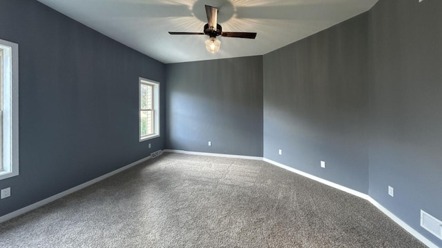 empty room featuring ceiling fan and carpet