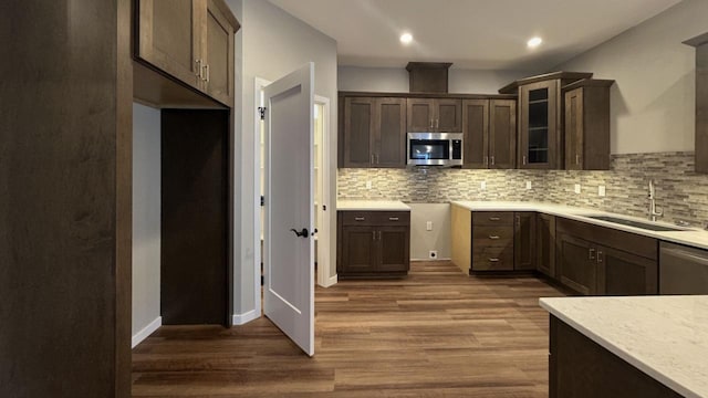 kitchen featuring appliances with stainless steel finishes, dark hardwood / wood-style floors, tasteful backsplash, and sink