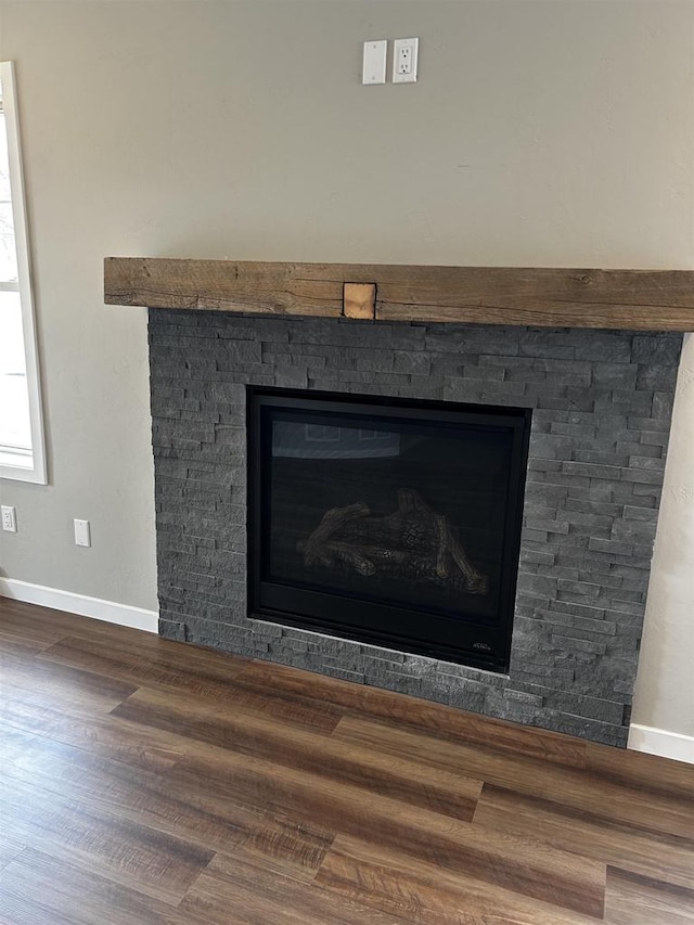 details with a stone fireplace and wood-type flooring