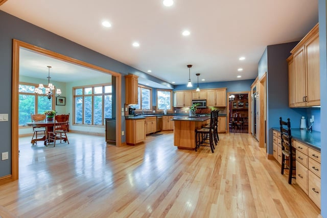 3310 Saracen Way, Verona, WI 53593 - kitchen featuring dark countertops, a breakfast bar area, light wood-style flooring, stainless steel appliances, and recessed lighting