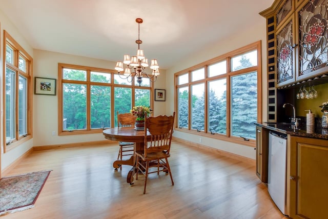 3310 Saracen Way, Verona, WI 53593 - dining room with a chandelier, bar with sink, and light wood finished floors