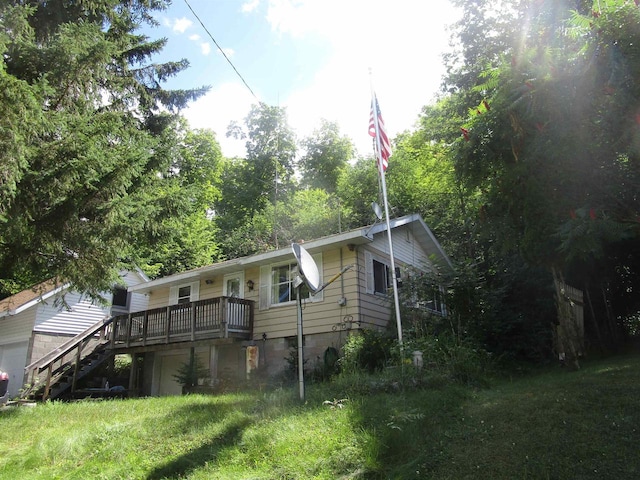 view of front of house with a deck and a front lawn