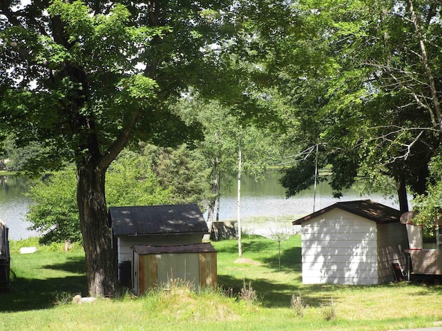 view of yard featuring a storage unit and a water view