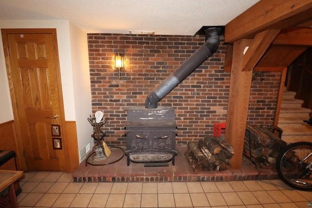 details featuring a wood stove, wood walls, and a textured ceiling