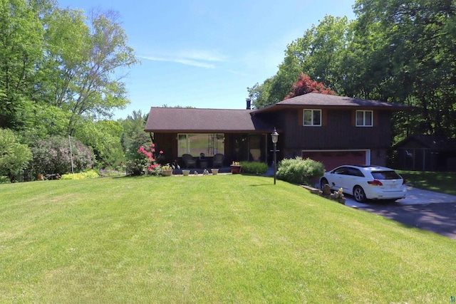 tri-level home featuring a front yard and a garage