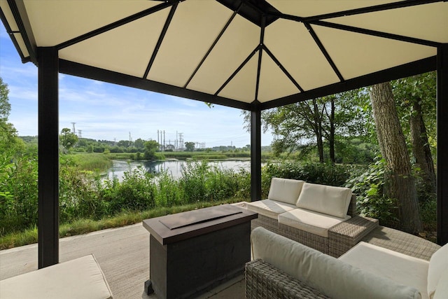 view of patio / terrace featuring a water view and an outdoor living space with a fire pit