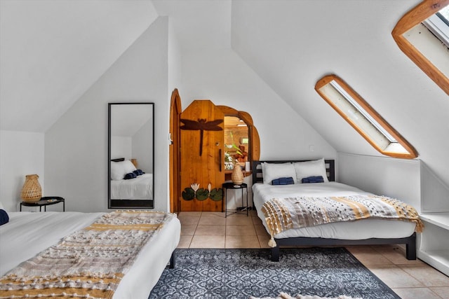 bedroom with tile flooring and vaulted ceiling with skylight