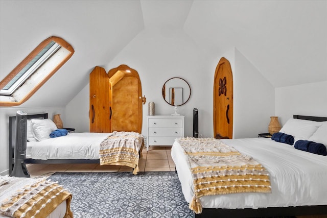 tiled bedroom with vaulted ceiling with skylight